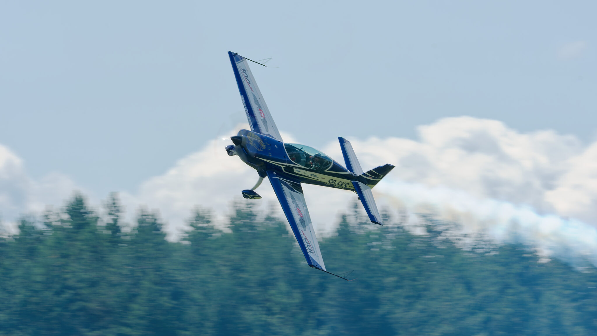 Przelot SP-EKS z dymem nad linią drzew