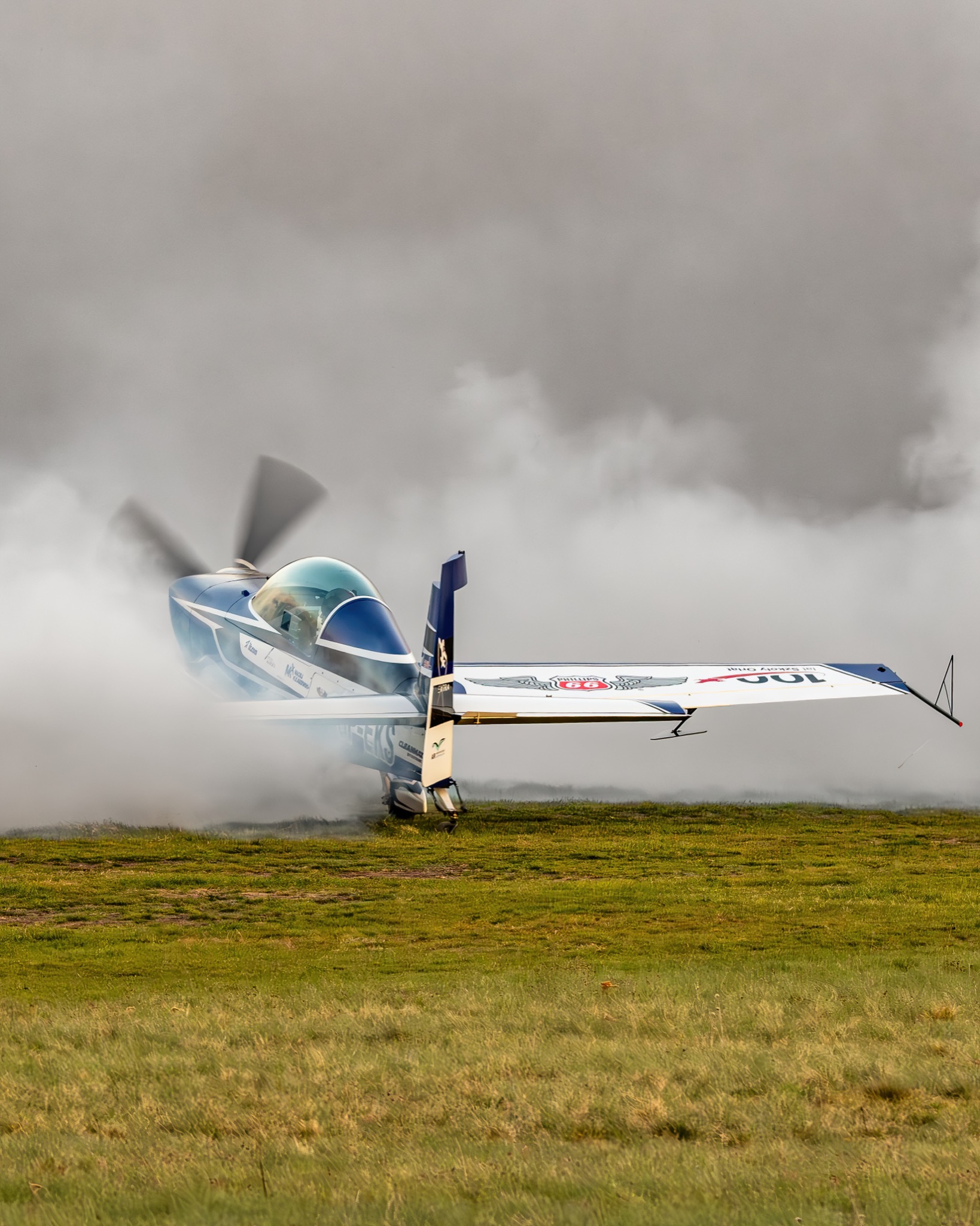 SP-EKS w chmurze dymu na trawie lotniska